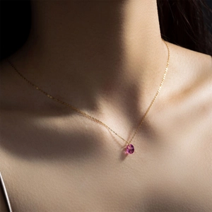 Collier en argent S925 doré avec pendentif gemme rose ovale sur le cou du mannequin