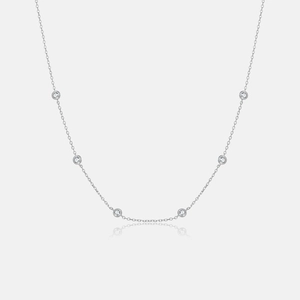 Detail of S925 silver necklace with six bezel-set round zircons on a delicate chain