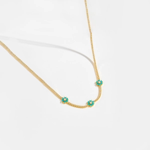 Detail of gold floral necklace with turquoise petals and micro-pave white zircon stones