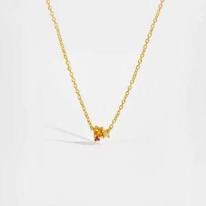 Detalle de collar dorado con piedras amarillas, rosas y claras engastadas en garras