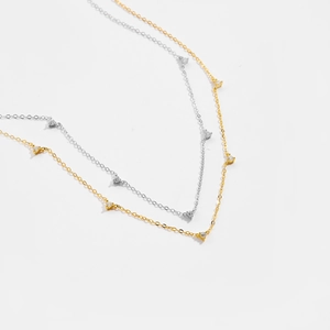 Detail of minimalist S925 silver and gold dainty necklaces with tiny triangle zircon pendants