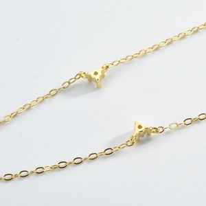 Macro shot of gold-plated chain featuring two sparkling cubic zirconia prong settings