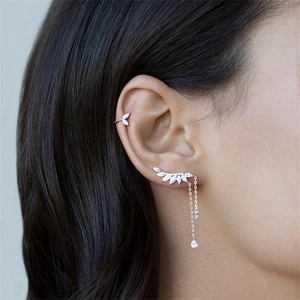 Détail du bijou d'oreille en argent en forme de feuille avec pampille sur modèle