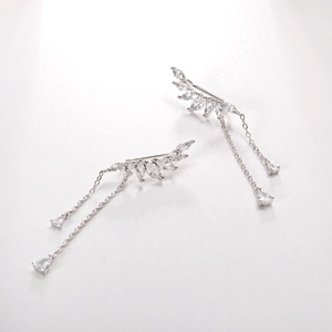 Gros plan sur clips d'oreilles feuilles en argent S925 avec ailes en zircon et pompons