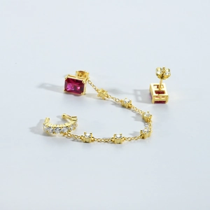 Détail de boucles d'oreilles pompons en argent S925 plaqué or avec pierres rouges carrées