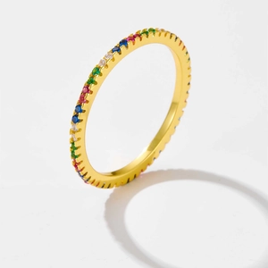 Detailed close-up of a gold-plated band ring with colorful rainbow zircons pavé set