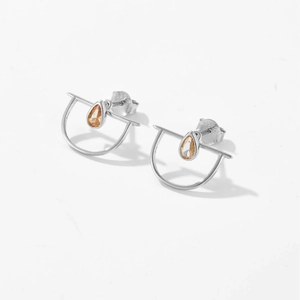 Primer plano del sello S925 en pendientes de gota de plata con gema naranja