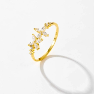 Detalle del anillo de flor en plata S925 con acabado dorado y cristales talla marquesa
