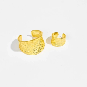 Detail of adjustable gold ring and ear cuff featuring a textured hammered metal surface