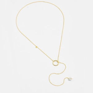 Detail der goldenen Y-Kette mit poliertem Ringelement und einer edlen weißen Perle am Ende