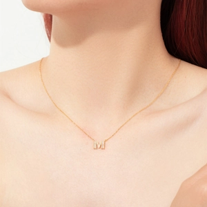 Collier minimaliste en argent s925 avec pendentif lettre M doré et zircons sur un mannequin