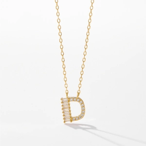 Gros plan d'un collier en argent s925 doré avec un pendentif lettre D serti de cristaux