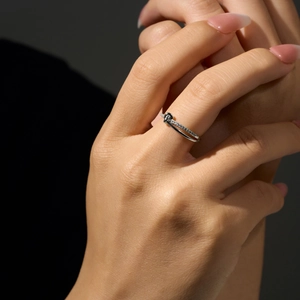 Detail of s925 silver knot ring with white zircon stones on woman finger