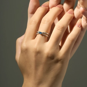 Macro detail of S925 silver ring featuring a blue gemstone and crisscross diamond band