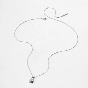 Détail macro du pendentif appareil photo en argent S925 avec perle sur une chaîne fine
