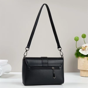 Detail of black crossbody bag showing pebbled leather texture and back zipper pocket