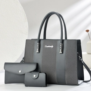 Three-piece dark grey tote bag set with textured vertical stitching and silver hardware