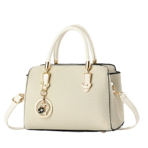 Beige woven handbag with gold hardware and heart pendant on a clean white background