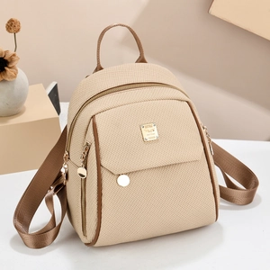 Minimalistischer beiger Rucksack mit braunem Kunstlederbesatz und goldener Metallplatte