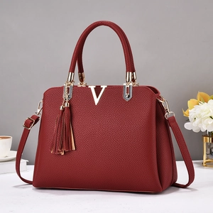 Sac à main bordeaux en cuir avec logo V doré et pendentif à pompon élégant