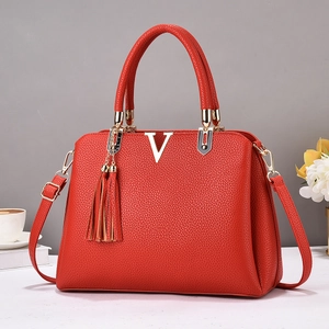 Sac à main rouge en cuir grainé avec logo V doré et pendentif à pompon élégant