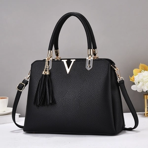 Détail de la texture grain lychee noire sur le sac à main avec logo en métal doré V