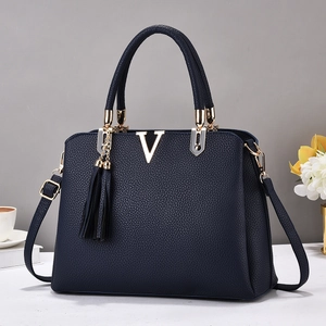 Sac à main bleu marine en cuir litchi avec ornement en V doré et détail de gland