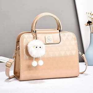 Beige patent leather quilted handbag with metal ring handles and plush ball charm