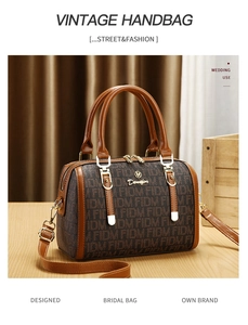 Detail of vintage Boston bag featuring retro monogram pattern and brown leather handles