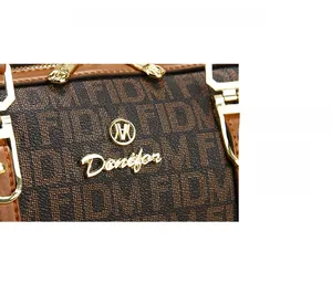 Detailed macro view of the vintage monogram pattern and gold Denifor logo on the handbag