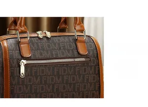 Detail view of the rear anti-theft zipper pocket on retro monogrammed handbag with gold hardware
