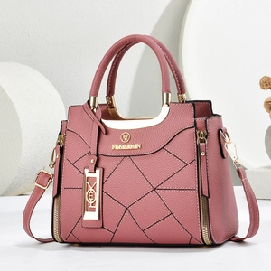 Dettaglio borsa rosa in finta pelle con cuciture a rombi e finiture dorate lucide