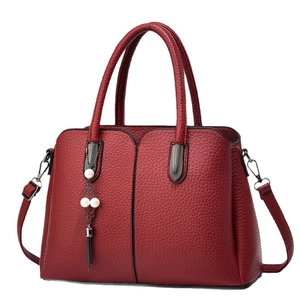 Sac à main bordeaux en cuir grainé avec pendentif perle et bandoulière amovible