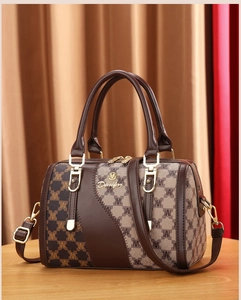 Close-up of Denfor brand metal logo and monogram pattern on brown Boston handbag