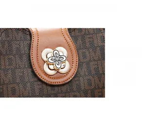 Détail du sac à main marron avec logo, fermoir magnétique et pendentif doré