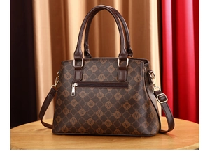 Close-up of the vintage monogram pattern handbag with gold hardware on a wooden table