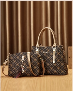Close-up of printed pattern on two-piece handbag set with golden metallic details