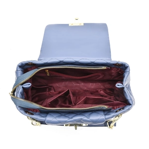 Detail of blue quilted bag showing spacious interior compartments and red lining