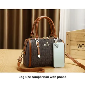 Deep brown Boston bag size comparison with a smartphone showing portable scale and design