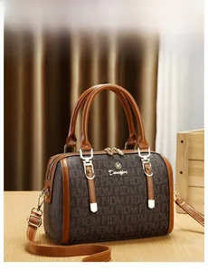 Detailed close-up of brown Boston handbag showing FIDM monogram and golden logo