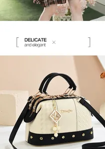 Detail of woven texture handbag with pearl pendant and gold hardware accents