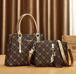 Close-up of two-piece tote and crossbody bag set with vintage pattern and cat charm