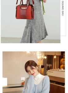 Close-up of red crocodile pattern square handbag with gold hardware and zipper detail