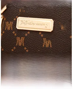 Close-up of Togo leather texture and gold metal logo plaque on the brown handbag