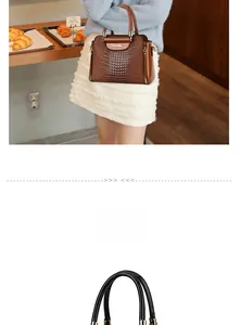Detail view of brown crocodile-patterned handbag with golden hardware and twin handles