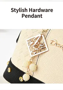 Detail of golden hardware charm with white pearls on a textured cream leather handbag