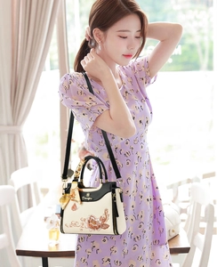 Close-up of Chinese style floral embroidery on a chic beige handbag with silk scarf handle