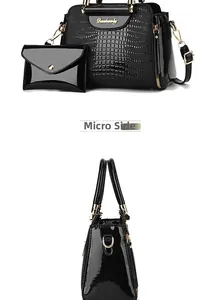 Detail view of black crocodile pattern faux leather handbag set with gold hardware