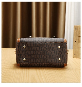 Detail view of the handbag base with protective gold-tone studs and monogram canvas