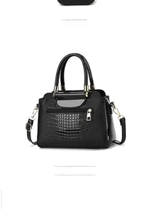 Detail view of the black crocodile pattern handbag showing side and back zipper pocket